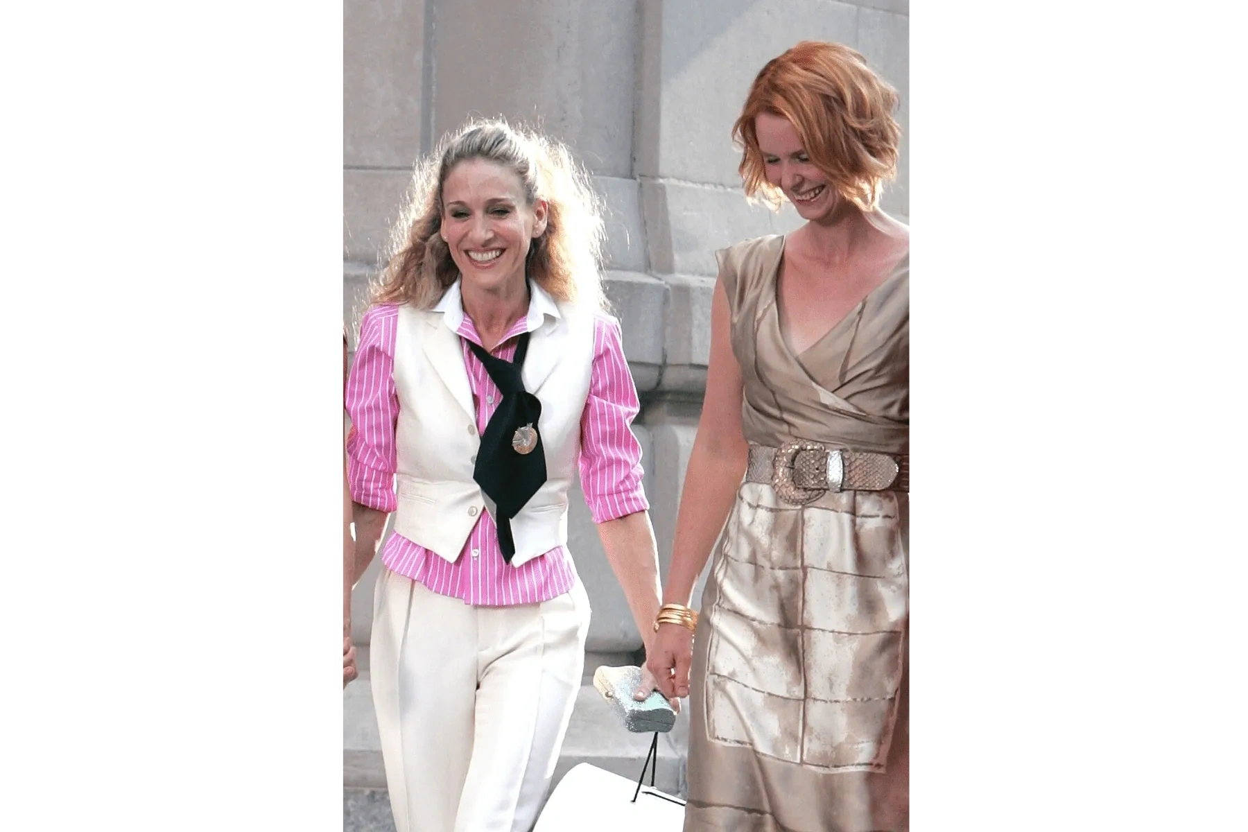 Carrie and Miranda walking hand in hand past a Manhattan landmark in Sex and the City